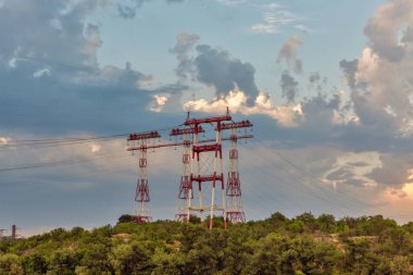 Ukrayna 'nın Khorytsia adasında günbatımında yüksek voltajlı elektrik hatları kuleleri.