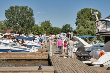 KYIV, UKRAINE - Haziran 05, 2015: İnsanlar Chervona Kalyna yat kulübünde yelken açmak için en son teknolojilere sahip IBYS, Uluslararası Tekne ve Yat Şovu sırasında Dinyeper nehri üzerinde demirlemiş modern yatları ziyaret ediyorlar.