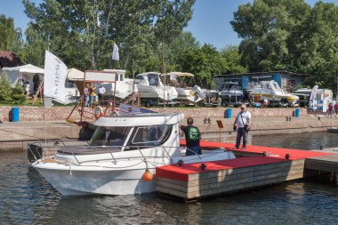 KYIV, UKRAINE - Haziran 05, 2015: İnsanlar Chervona Kalyna yat kulübünde yelken açmak için en son teknolojilere sahip IBYS, Uluslararası Tekne ve Yat Şovu sırasında Dinyeper nehri üzerinde demirlemiş modern yatları ziyaret ediyorlar.
