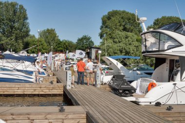 KYIV, UKRAINE - Haziran 05, 2015: İnsanlar Chervona Kalyna yat kulübünde yelken açmak için en son teknolojilere sahip IBYS, Uluslararası Tekne ve Yat Şovu sırasında Dinyeper nehri üzerinde demirlemiş modern yatları ziyaret ediyorlar.