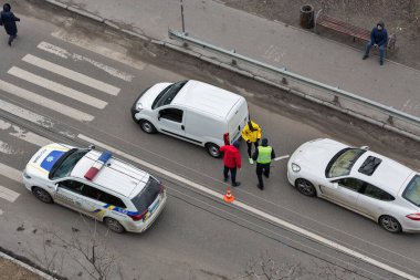 KYIV, UKRAINE - Şubat 02, 2020: Bir polis arabası yaya geçidinde bir trafik kazası geçirdi ve aracın dışında kimliği belirsiz sürücüler duruyordu. Yukarıdan görüntüle.