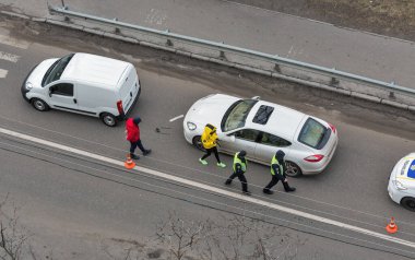 KYIV, UKRAINE - Şubat 02, 2020: Bir polis arabası yaya geçidinde bir trafik kazası geçirdi ve aracın dışında kimliği belirsiz sürücüler duruyordu. Yukarıdan görüntüle.