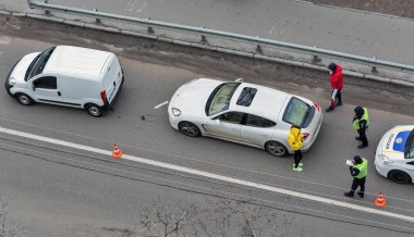 KYIV, UKRAINE - Şubat 02, 2020: Bir polis arabası yaya geçidinde bir trafik kazası geçirdi ve aracın dışında kimliği belirsiz sürücüler duruyordu. Yukarıdan görüntüle.