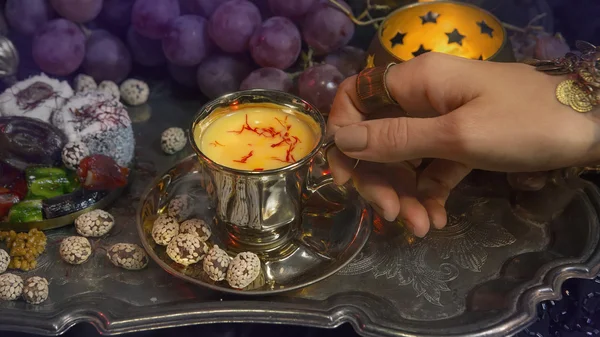 Mains féminines avec des bijoux orientaux Verser le thé dans la tasse. Tradit — Photo