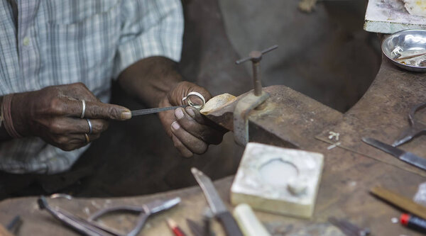 Indian Jeweler making an Oriental Jewelry in workshop. Handmade traditional jewel Manufacturing in Jaipur (Rajasthan). Jewelry Manufacturing Process in India. Indian Silver and Gold Jewel and Gems