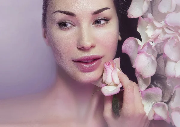 Frau mit frischen Rosenblättern und rosa Rosenknospen. Natürliches Rosenwasser — Stockfoto