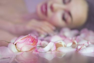 Taze Gül yaprakları ve pembe gül goncası. Clea bulanık kadın yüzü