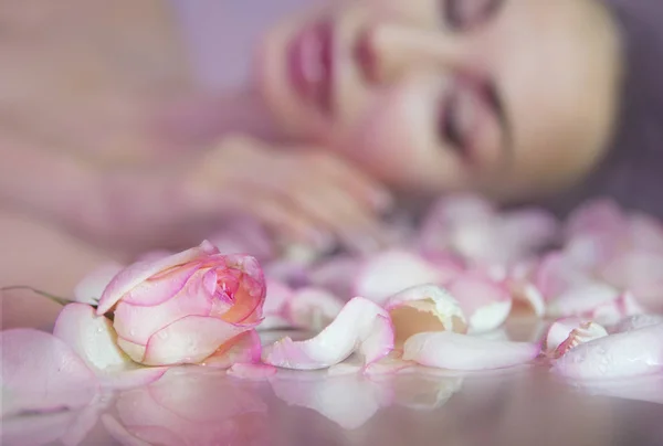 Fresh Rose petals and pink rosebud. Blurred Woman face with clea — Stock Photo, Image