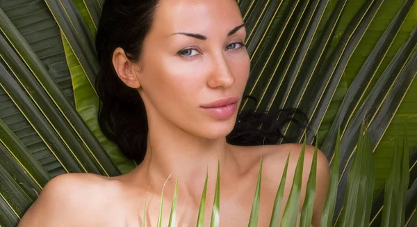 Sexy mooie vrouw zonnen onder palm bladeren. Spa buiten, — Stockfoto