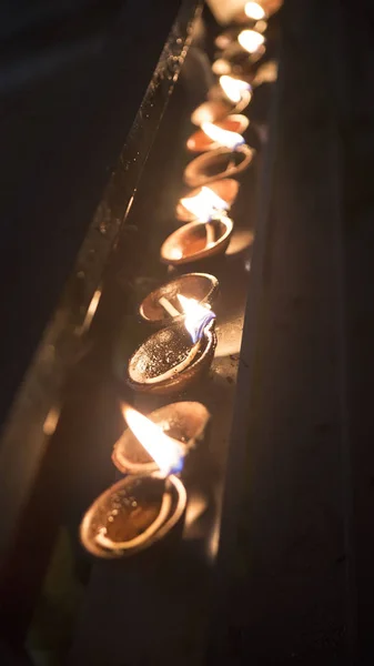 Candles in a Buddhist temple. Meditation at the Buddha Temple. Lot of Beautiful Candles. Flame close-up in the Sri Lanka Temple on a Religious Festival. Oil Lamp. Spiritual, Mystical Traditions of Asia. Bright festive lights. Infinity
