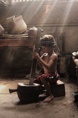 Küçük çocuklar geleneksel olarak pirinç dövüyorlar.