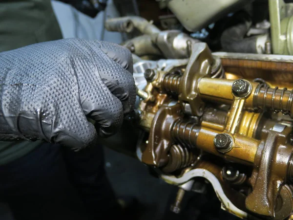 The connecting rod, piston and cylinder block in a disassembled condition. Man`s hand fixing a engine