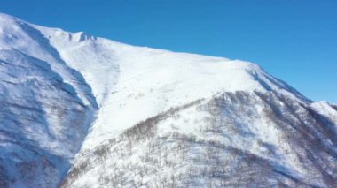 Kamçatka Yarımadası, Rusya 'nın doğası. Karlı dağların havadan görünüşü. Taşrada. 4K drone videosu. İHA 'dan video çekimi. UNESCO dünya doğal ve kültürel mirası. Dağlarda kar.