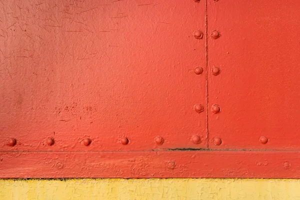 Simetrik yatay ve dikey metal perçinlerle kırmızı ve sarı endüstriyel yapı