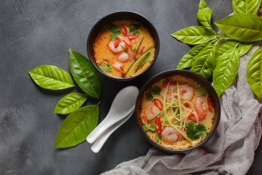 Laksa Çorbası içinde taze fasulye filizi, salatalık, limon, kırmızı biber ve kişniş bulunan karidesli Hint cevizli köri çorbası.