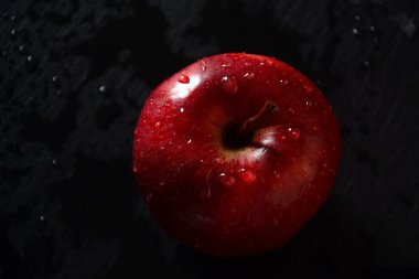 Kırmızı elma ve koyu arkaplanda bir yığın kitap. Okul konseptine dönelim.