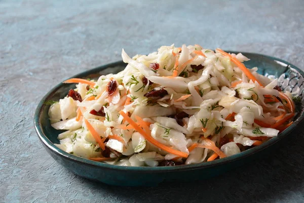Cabbage salad with carrot, smoked almonds and dried cranberries. Coleslaw Salad.Fermented cabbage- Russian cuisine. Healthy vegan food concept.