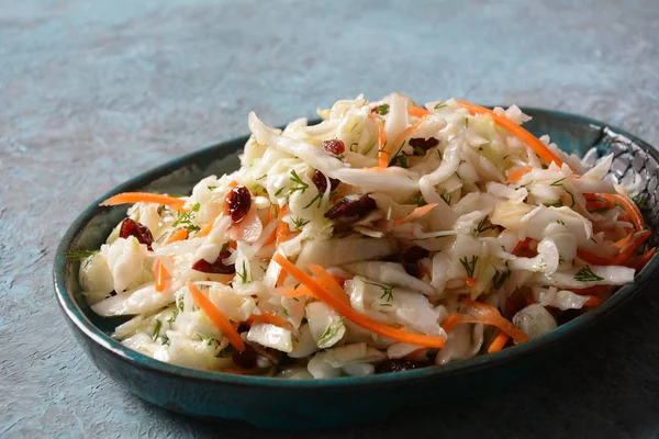 Cabbage salad with carrot, smoked almonds and dried cranberries. Coleslaw Salad.Fermented cabbage- Russian cuisine. Healthy vegan food concept.