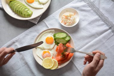 Healthy breakfast concept, fried eggs, avocado and smoked salmon, top view