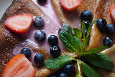 Taze yaban mersinli, naneli ve çilekli krep. Sağlıklı kahvaltı kavramı