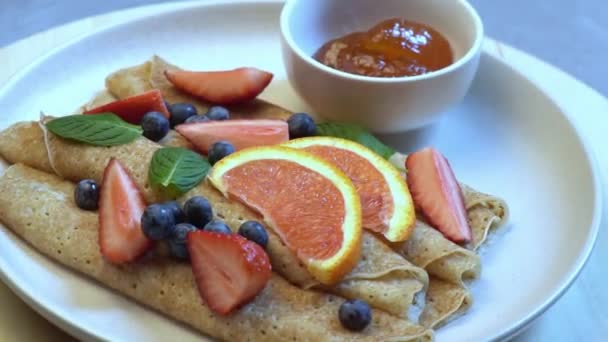 新鮮なミント イチゴ ブルーベリー オレンジ ジャムで包まれた甘いパンケーキ 健康的な朝食のコンセプト — ストック動画