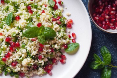 Kuskus, taze nane, salatalık, nar, limon ve zeytinyağlı sağlıklı salata. Doğu mutfağı. Vegan gıda konsepti. Geleneksel İsrail yemekleri