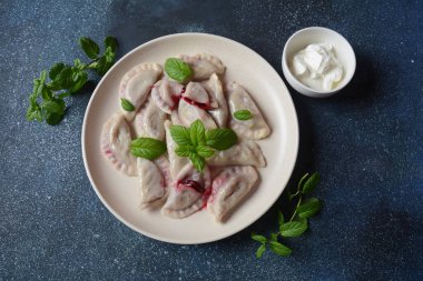 Kirazlı börek, ekşi krema ve nane. Ukrayna, Rusya ve Beyaz Rusya mutfağı. Sağlıklı kahvaltı.