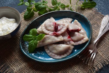 Kirazlı börek, ekşi krema ve nane. Ukrayna, Rusya ve Beyaz Rusya mutfağı. Sağlıklı kahvaltı.