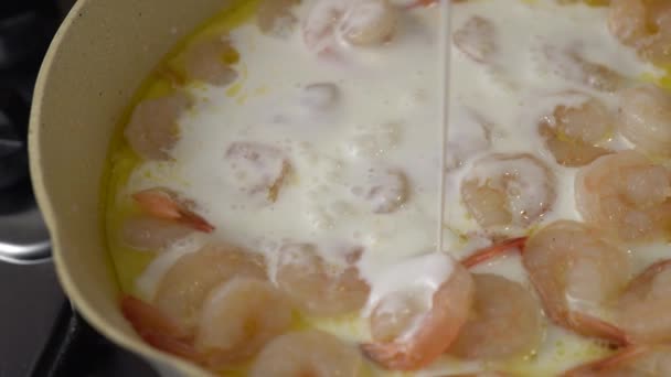 添加奶油到潘创建酱汁 将奶油倒入盛有虾仁的平底锅中 制成奶油酱汁 — 图库视频影像