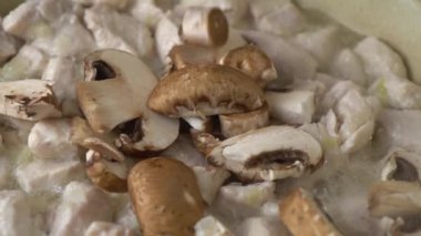 Kızarmış tavuk etine taze mantar ve kızgın yağ ekleniyor..