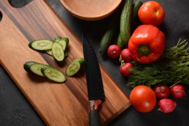 Mutfak tahtasındaki sebzeleri doğramak. Salata hazırlamak ya da pişirmek
