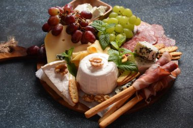 Atıştırmalık aperatifler. Antipasto Peynir Kurulu, salam ve bir bardak şarapla servis edilen Grissini ekmek çubuklarıyla jambon kabuğu. Geleneksel Fransız, İspanyol veya İtalyan gıda kavramı