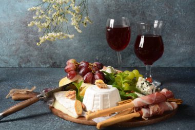 Atıştırmalık aperatifler. Antipasto Peynir Kurulu, salam ve bir bardak şarapla servis edilen Grissini ekmek çubuklarıyla jambon kabuğu. Geleneksel Fransız, İspanyol veya İtalyan gıda kavramı