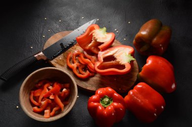 Mutfak tahtasındaki kırmızı biberi bıçakla kesmek. Salata ya da yemek hazırlama. Aşçı ya da aşçı konsepti. Profesyonel mutfak.