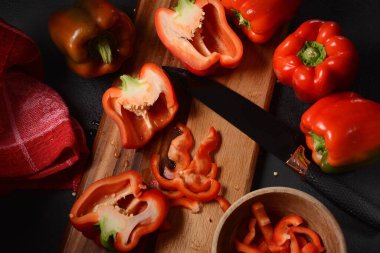 Mutfak tahtasındaki kırmızı biberi bıçakla kesmek. Salata ya da yemek hazırlama. Aşçı ya da aşçı konsepti. Profesyonel mutfak.