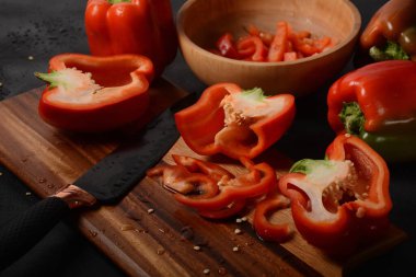 Mutfak tahtasındaki kırmızı biberi bıçakla kesmek. Salata ya da yemek hazırlama. Aşçı ya da aşçı konsepti. Profesyonel mutfak.