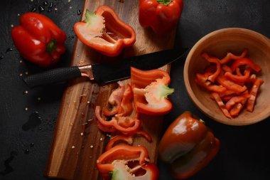 Mutfak tahtasındaki kırmızı biberi bıçakla kesmek. Salata ya da yemek hazırlama. Aşçı ya da aşçı konsepti. Profesyonel mutfak.