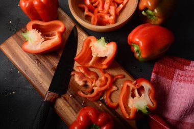 Mutfak tahtasındaki kırmızı biberi bıçakla kesmek. Salata ya da yemek hazırlama. Aşçı ya da aşçı konsepti. Profesyonel mutfak.