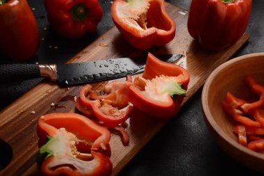 Mutfak tahtasındaki kırmızı biberi bıçakla kesmek. Salata ya da yemek hazırlama. Aşçı ya da aşçı konsepti. Profesyonel mutfak.