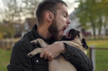 Yavru köpek esniyor. Sahibi ona bağırıyormuş gibi yapıyor..