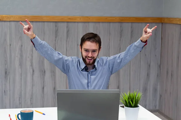 Retrato de un hombre que mira el portátil y levanta alegremente las manos. El concepto de buenas noticias, victoria y grandes logros —  Fotos de Stock