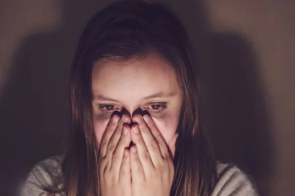 Verontrust jonge vrouw en bedekt haar mond met haar handen, kijkt naar het scherm en wordt bang, close-up — Stockfoto