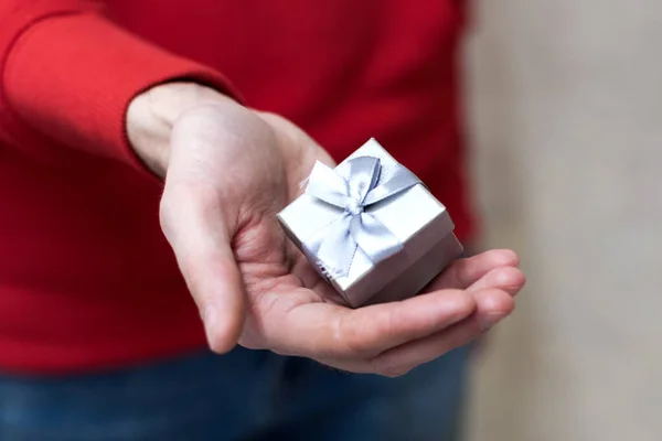 Nahaufnahme auf Händen Mann gibt eine kleine graue Geschenkbox — Stockfoto