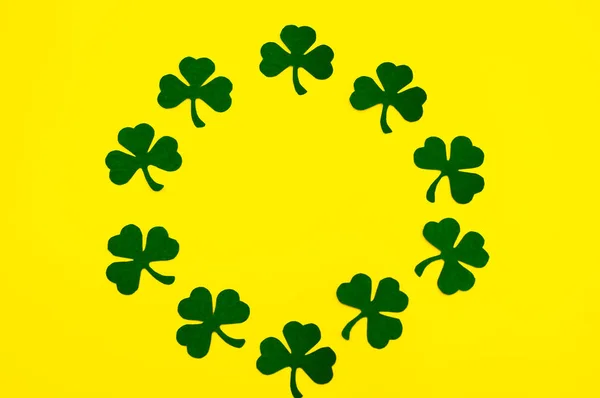 Happy Saint Patrick 's of handmade paper clover leaves on yellow background with copy space — стоковое фото