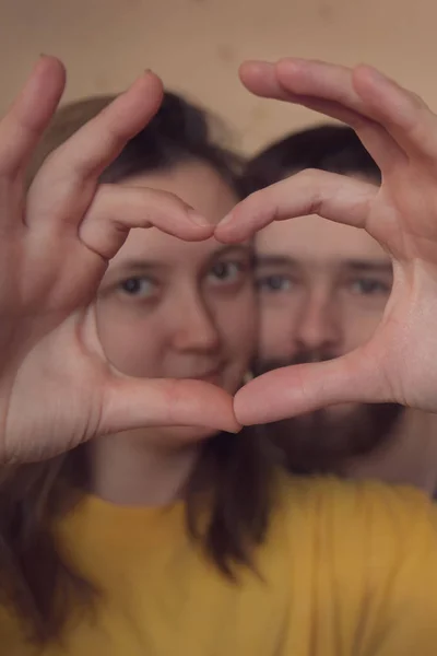 Primer plano de la pareja haciendo forma de corazón con las manos — Foto de Stock