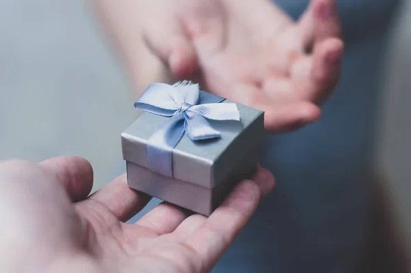 Mãos dando e recebendo um presente, close-up . — Fotografia de Stock