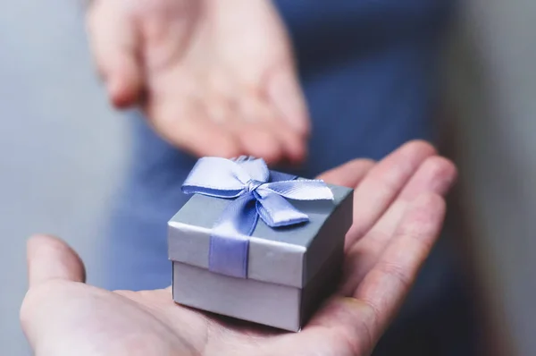 Handen geven en ontvangen van een cadeau, close-up. — Stockfoto