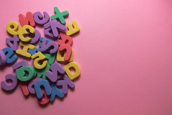 Színes műanyag ábécé betűk rózsaszín háttér másolási hely, felső nézet — Stock Fotó