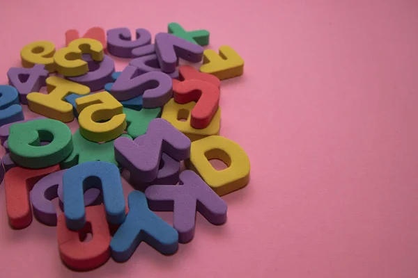Färgglada plast alfabetet bokstäver på rosa bakgrund med kopia utrymme, ovanifrån — Stockfoto