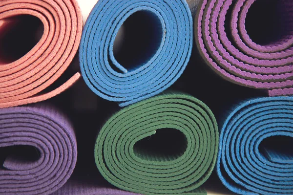 Vícebarevné podložky na jógu v tělocvičně — Stock fotografie